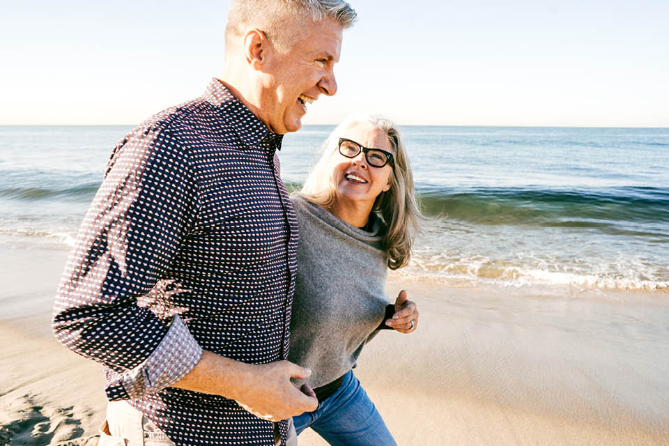 A couple taking a walk at the beach.