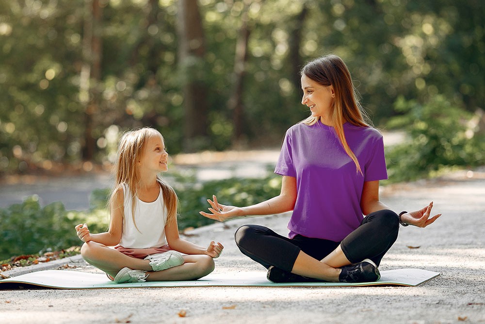 A mother and daughter practicing meditation.