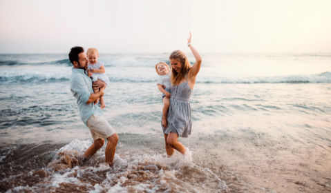 A family of four playing in the ocean.