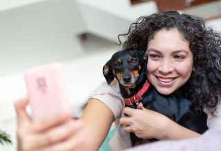 A person taking a selfie with a dog.