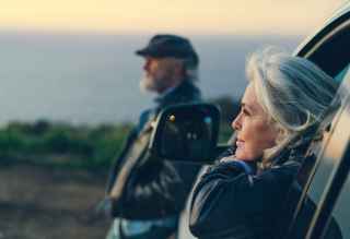 Couple looking into the distance from their car